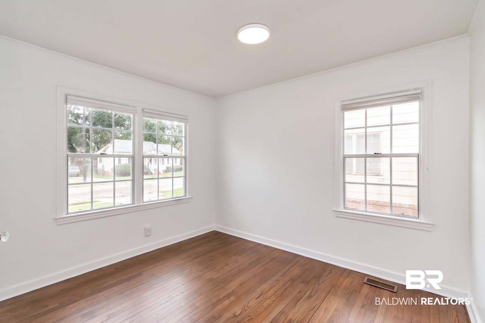 208 Morgan Avenue Mobile, AL 36606 - Photo 17 of 27 Empty room featuring wood-type flooring, plenty of natural light, and ornamental molding