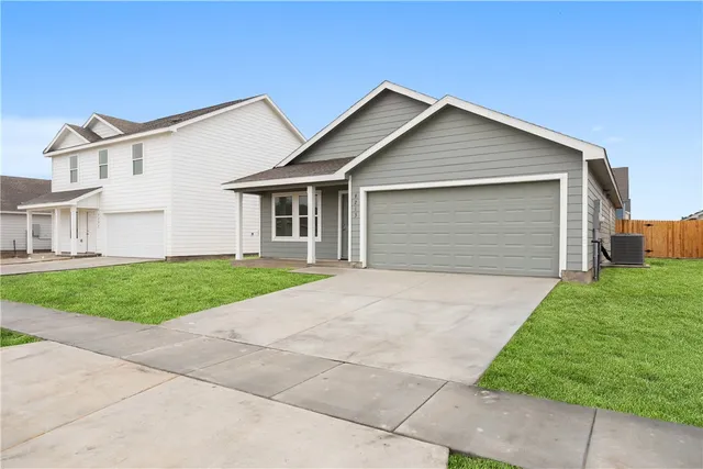 front view of house with a yard and potted plants