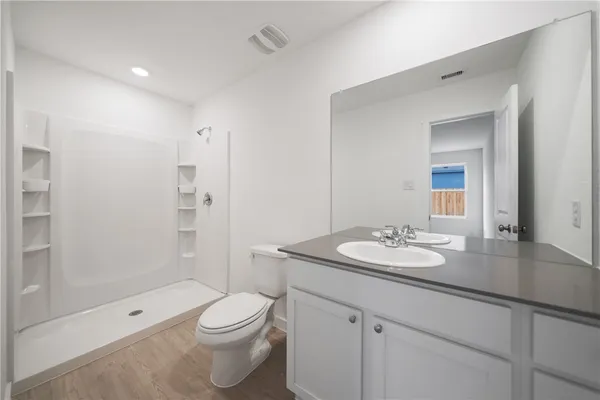 a bathroom with a sink a toilet and shower