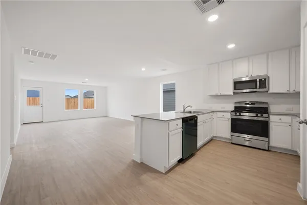 a kitchen with stove cabinets and wooden floor
