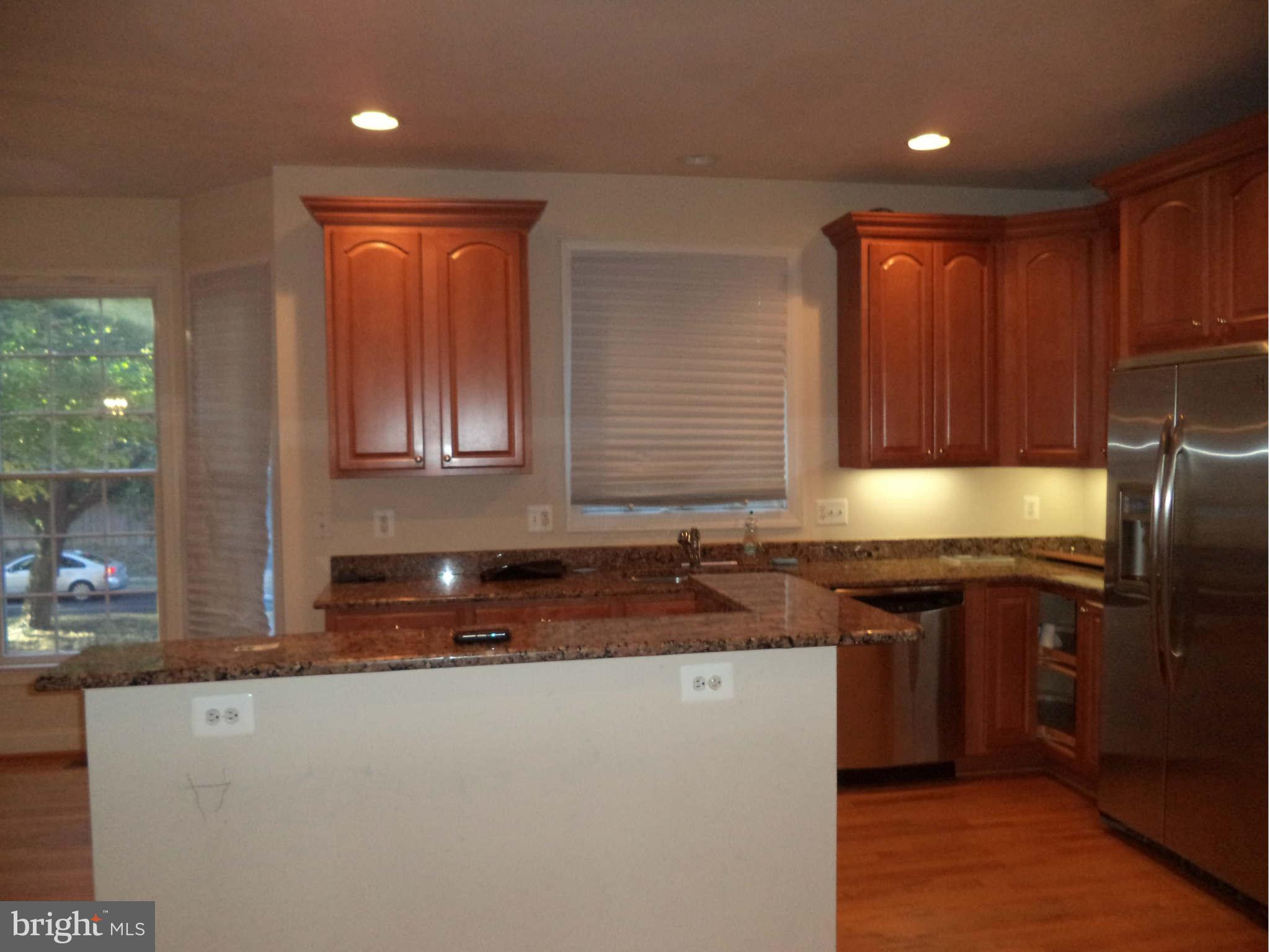 6812 Rigby Lane McLean, VA 22101 - Photo 11 of 23 a kitchen with granite countertop cabinets sink and stainless steel appliances