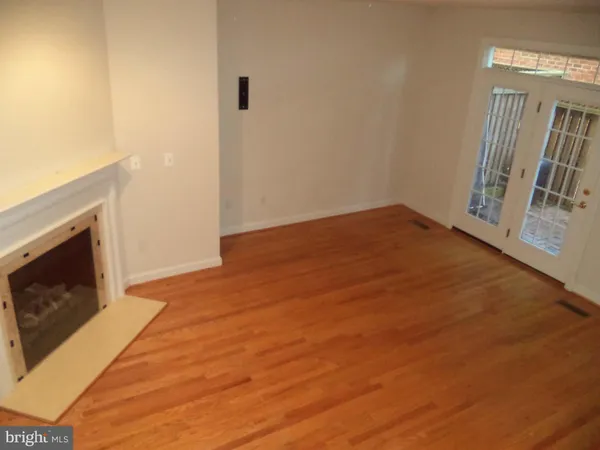 a view of empty room with wooden floor and fireplace