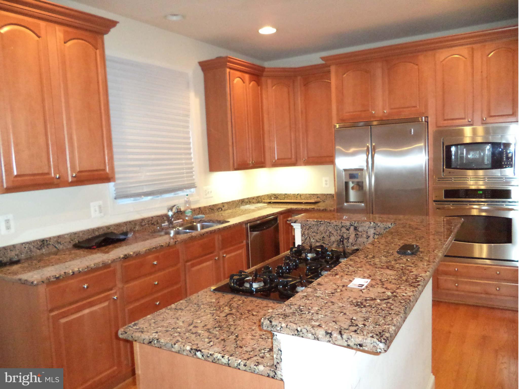 6812 Rigby Lane McLean, VA 22101 - Photo 8 of 23 a kitchen with stainless steel appliances granite countertop a sink stove and cabinets