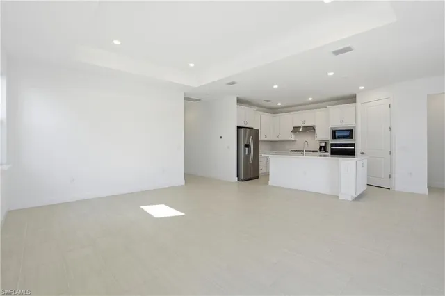 a view of kitchen with refrigerator and a stove top oven