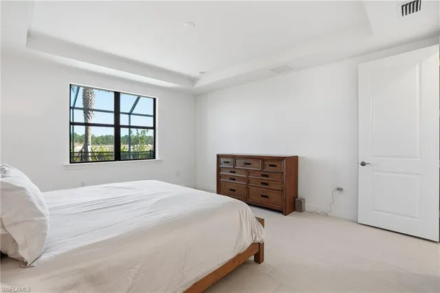 a bedroom with a bed dresser and a window