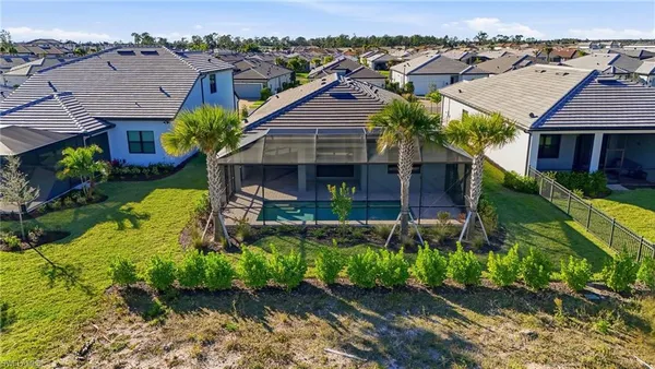 an aerial view of residential houses with outdoor space and parking