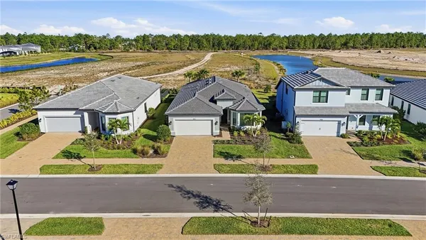 an aerial view of residential houses with outdoor space and river