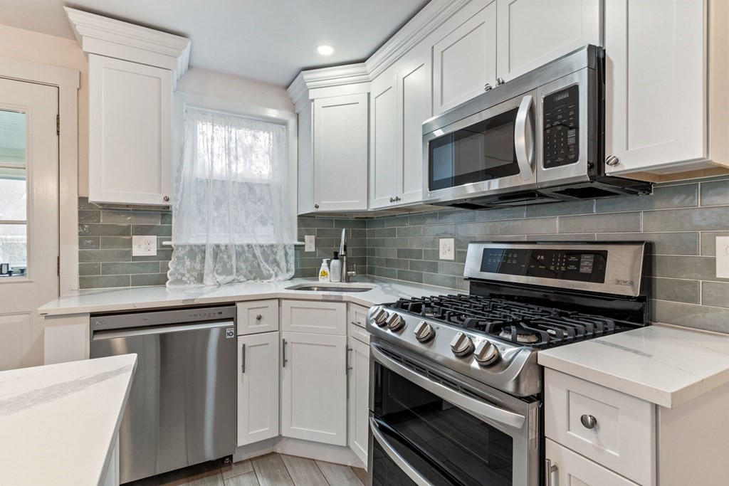 7 Meadowbrook Lane Ashland, MA 01721 - Photo 13 of 18 a kitchen with stainless steel appliances granite countertop a stove microwave and sink