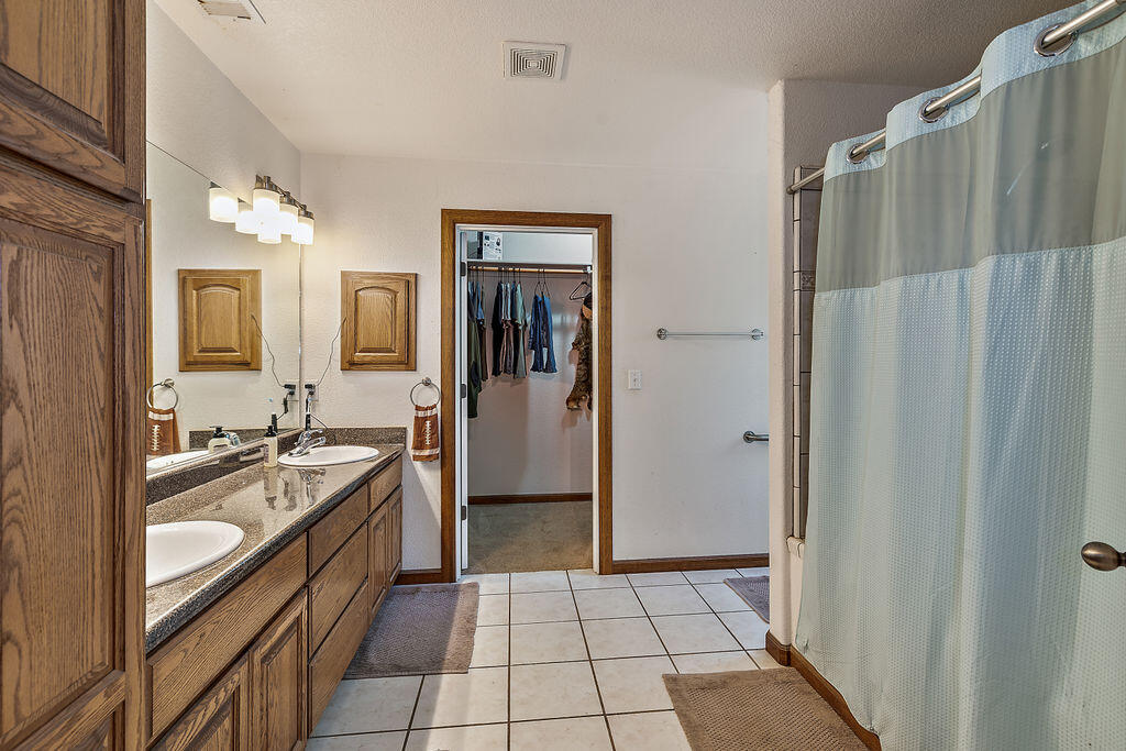 167 Rippling Way Merlin, OR 97532 - Photo 25 of 39 a spacious bathroom with a double vanity sink a mirror a bathtub and shower