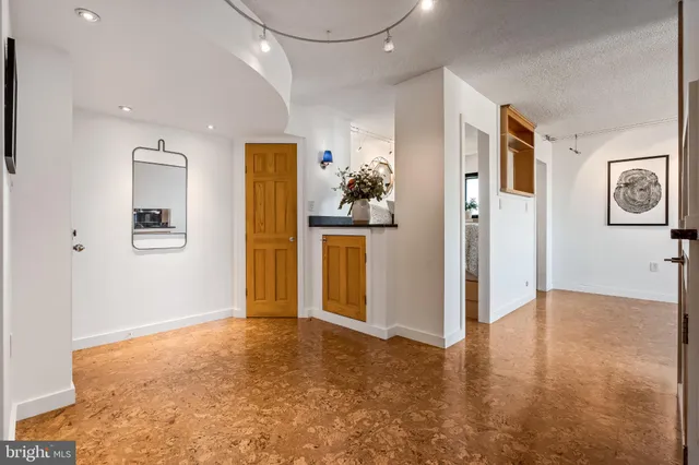 a view of a big room with wooden floor and windows