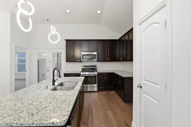 a kitchen with a sink a microwave a stove and refrigerator