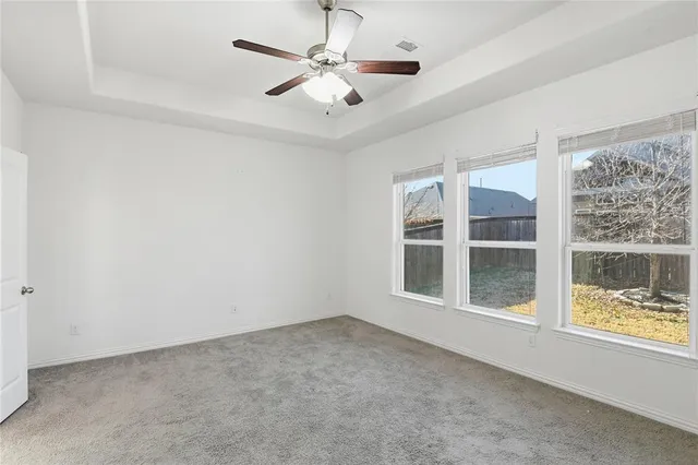 an empty room with a window and a fan