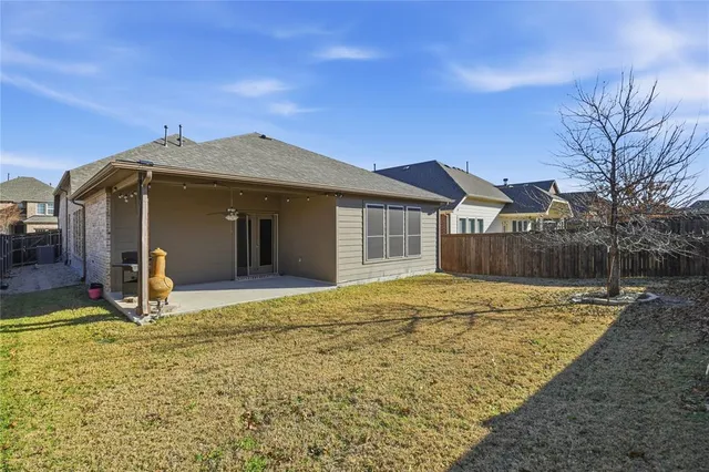 a view of a house with backyard and trees