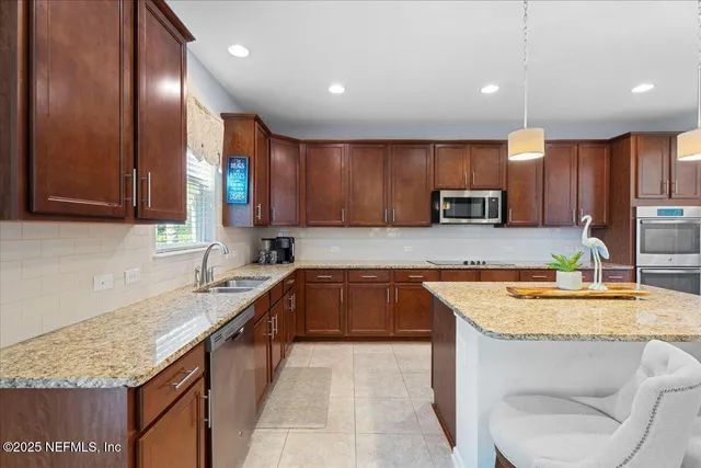 a kitchen with a sink a counter top space cabinets and stainless steel appliances