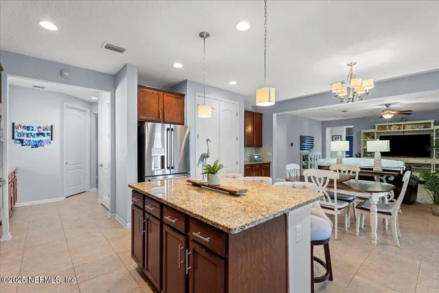 a kitchen with granite countertop kitchen island stainless steel appliances a table and chairs