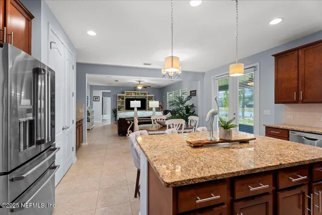 a kitchen with granite countertop kitchen island stainless steel appliances a sink table and chairs
