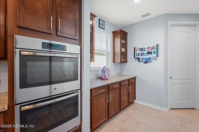 a kitchen with stainless steel appliances granite countertop a refrigerator and a stove top oven