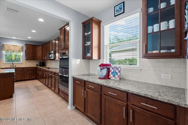 a kitchen with stainless steel appliances granite countertop counter space a sink cabinets and a window