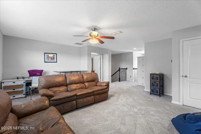 a living room with furniture and a ceiling fan