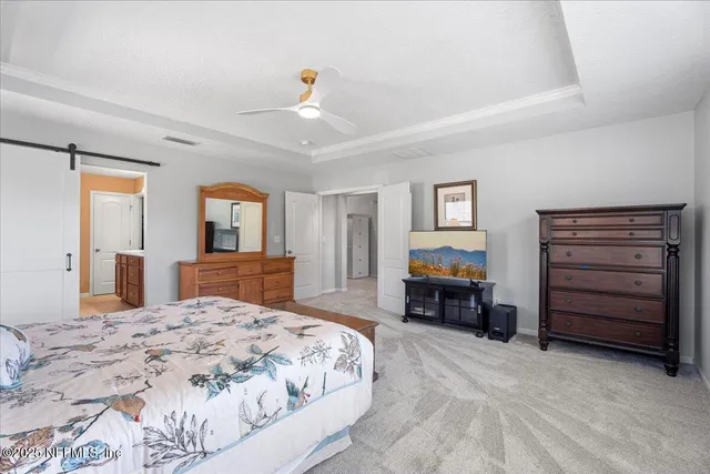 a large bedroom with a bed and wooden floor