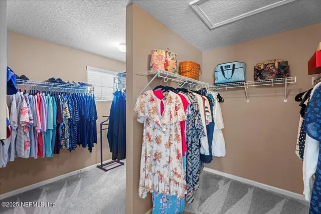 a view of walk in closet with clothes