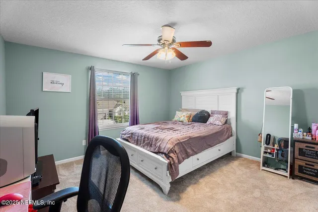a bedroom with a bed a chandelier and a dresser