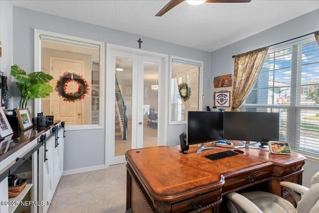 a view of a workspace with furniture and a window