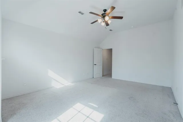 an empty room with a ceiling fan and a window