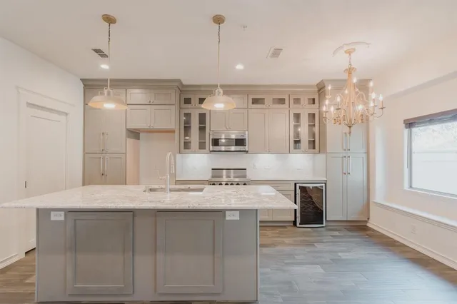 a kitchen with kitchen island granite countertop a stove and cabinets