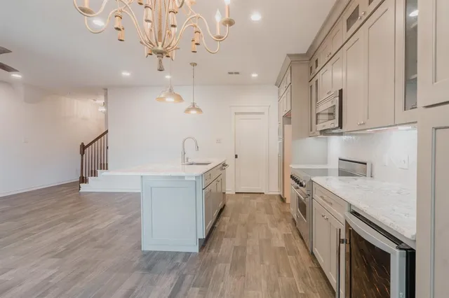 a open kitchen with a sink a counter top space stainless steel appliances and a ceiling fan
