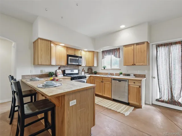 a kitchen with a stove a sink a microwave a island and a refrigerator