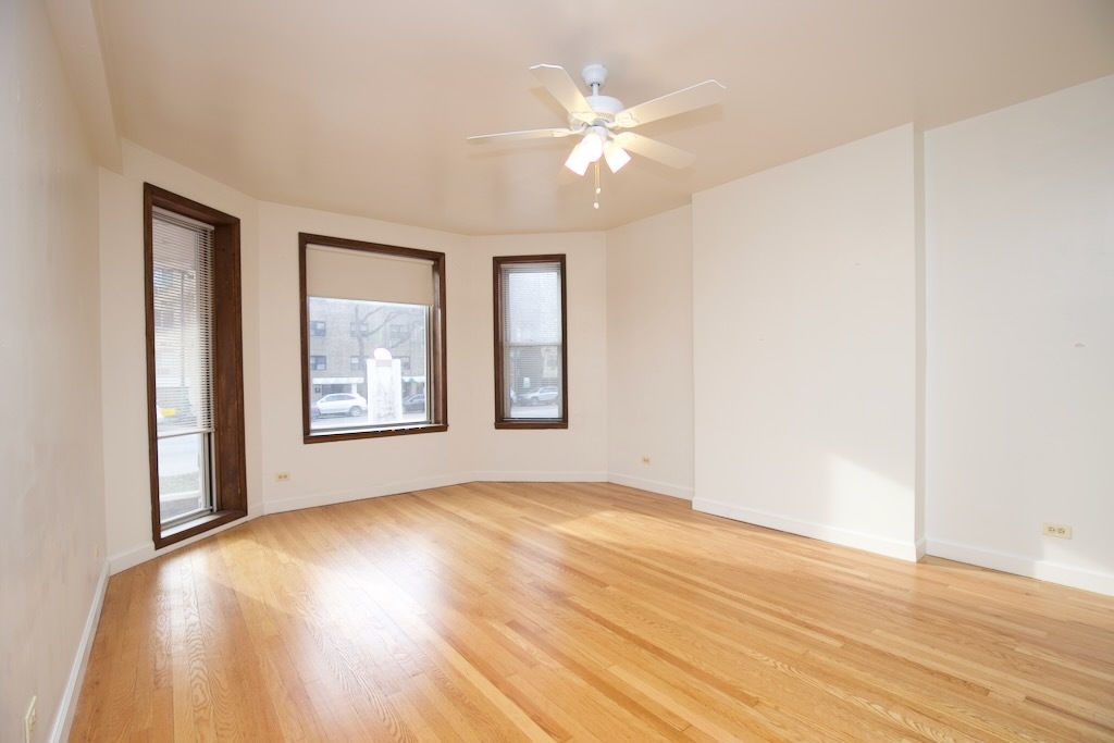 6711 North Sheridan Road, Unit 3S Chicago, IL 60626 - Photo 5 of 20 a view of an empty room with wooden floor and a window