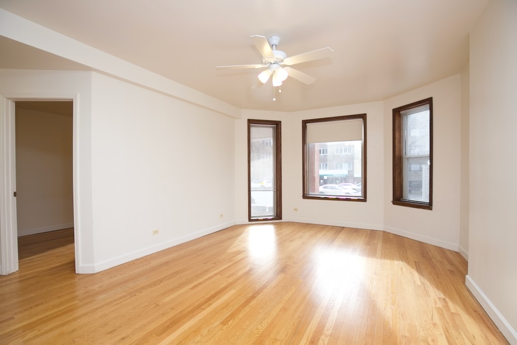 6711 North Sheridan Road, Unit 3S Chicago, IL 60626 - Photo 6 of 20 a view of an empty room with wooden floor and a window