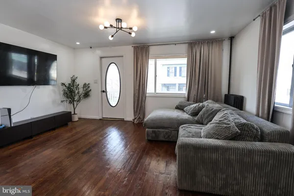 a living room with furniture a flat screen tv and a large window