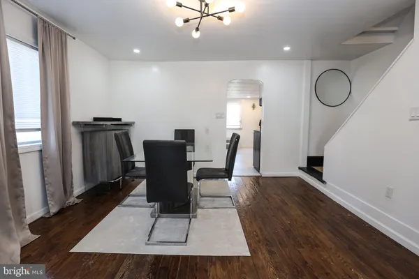 a view of a dining room with furniture a rug and wooden floor