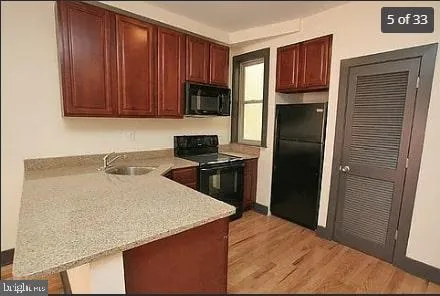 a kitchen with a refrigerator sink and cabinets