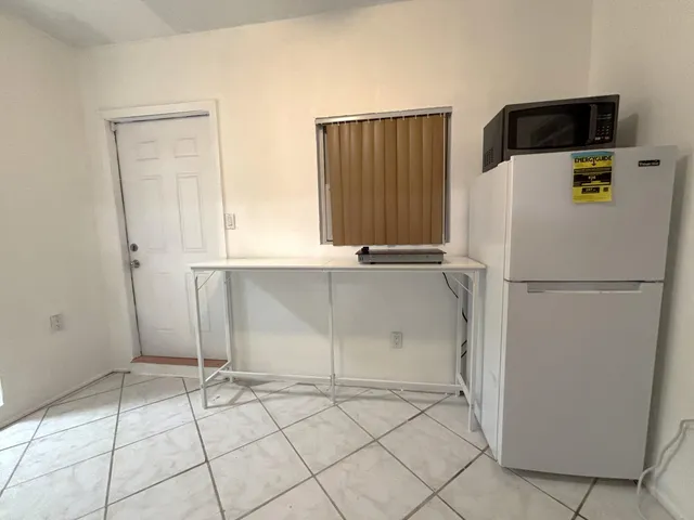 a white refrigerator freezer and a stove sitting inside of a kitchen