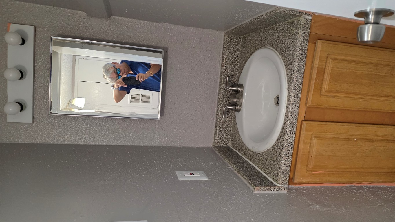 2124 Burton Drive, Unit 152 Austin, TX 78741 - Photo 13 of 16 a bathroom with a granite countertop sink a mirror and vanity
