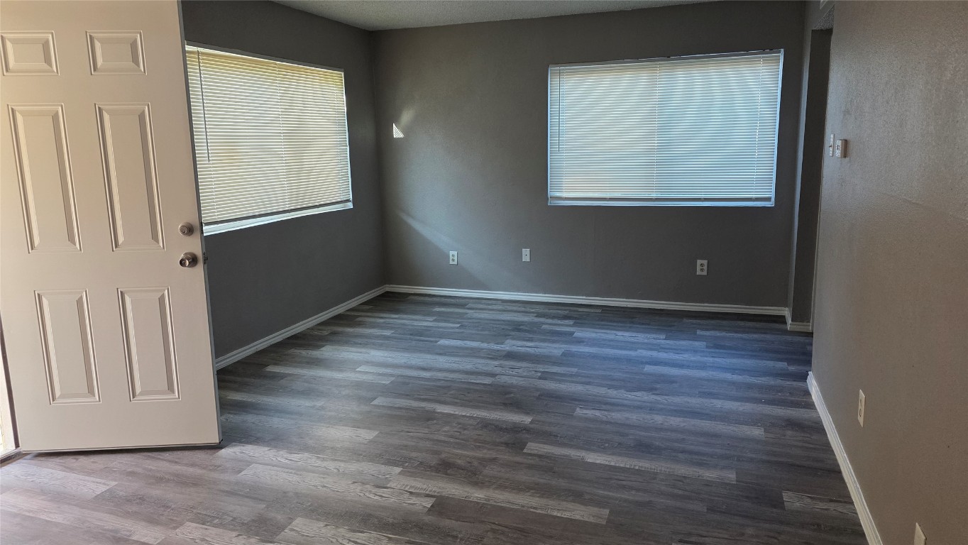2124 Burton Drive, Unit 152 Austin, TX 78741 - Photo 6 of 16 an empty room with wooden floor and windows