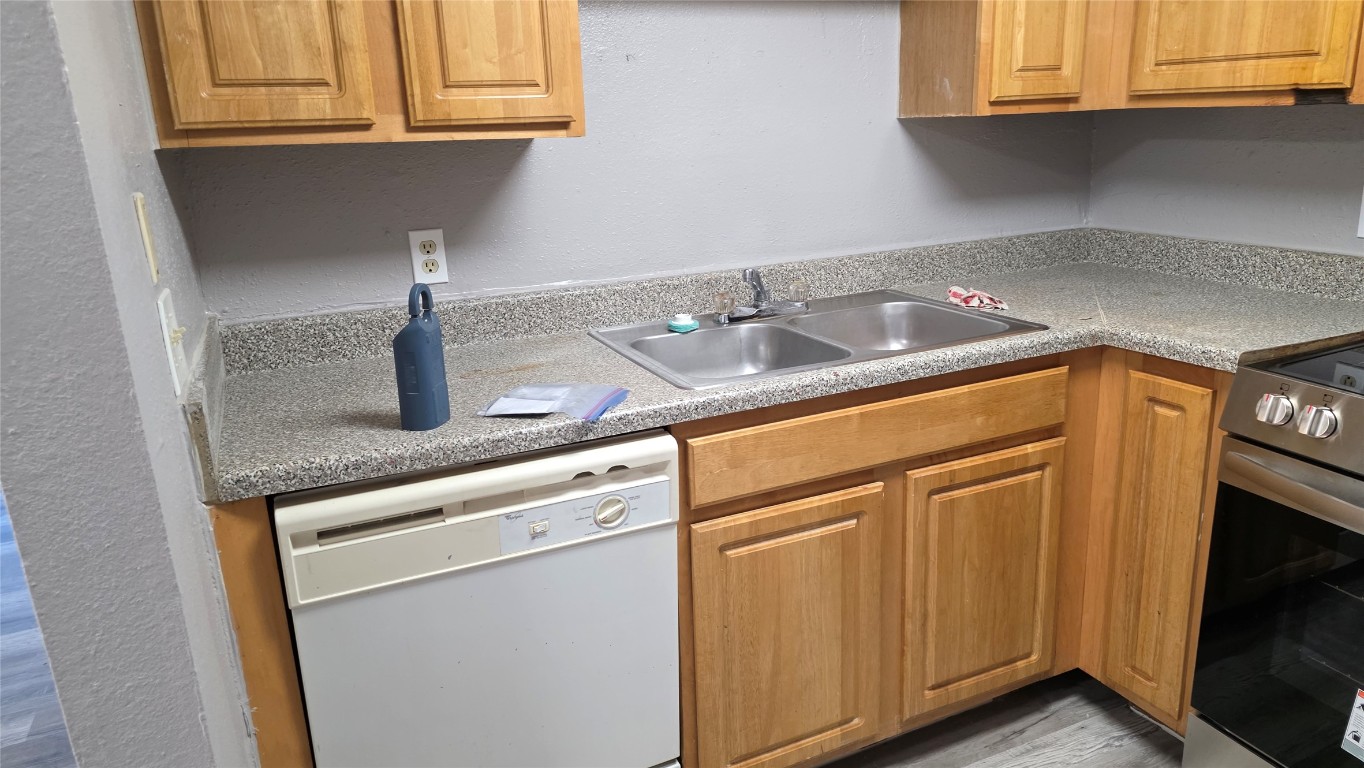 2124 Burton Drive, Unit 152 Austin, TX 78741 - Photo 8 of 16 a kitchen with granite countertop white cabinets and a sink