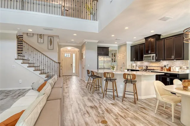 a dining room with wooden floor a chandelier a wooden table and chairs