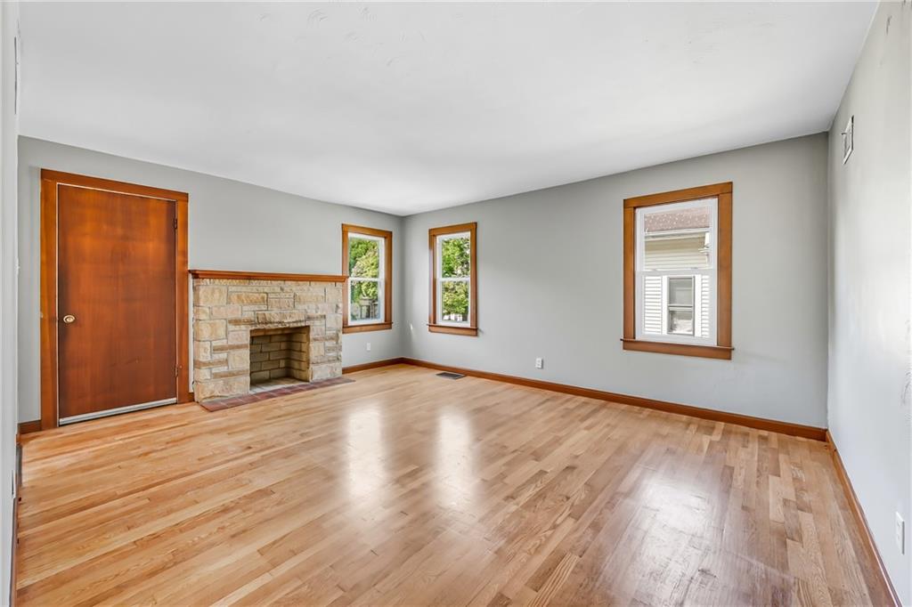 609 Park Avenue Farrell, PA 16121 - Photo 10 of 49 an empty room with wooden floor fireplace and windows