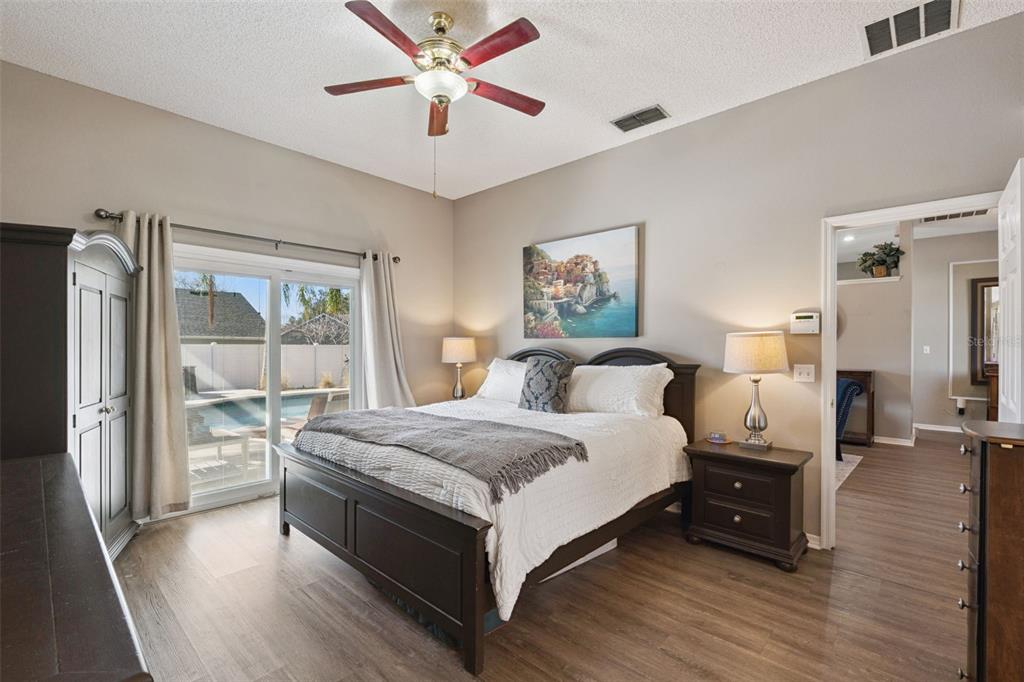 261 Mill Slough Road Oviedo, FL 32766 - Photo 20 of 62 a spacious bedroom with a bed and a chandelier