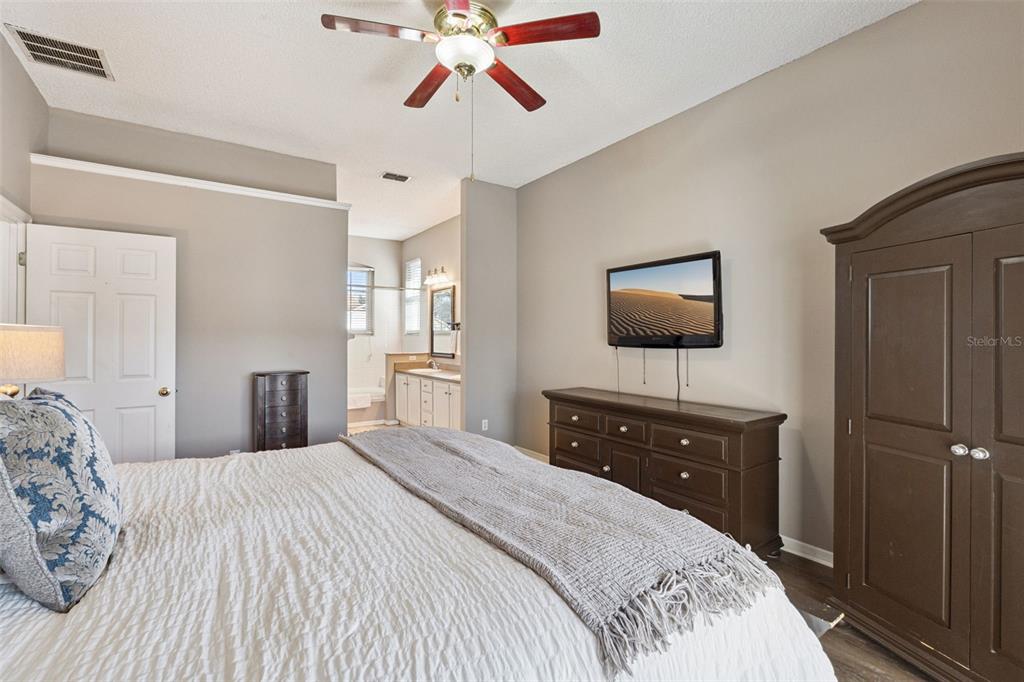 261 Mill Slough Road Oviedo, FL 32766 - Photo 22 of 62 a bedroom with a bed and a flat tv screen on dresser
