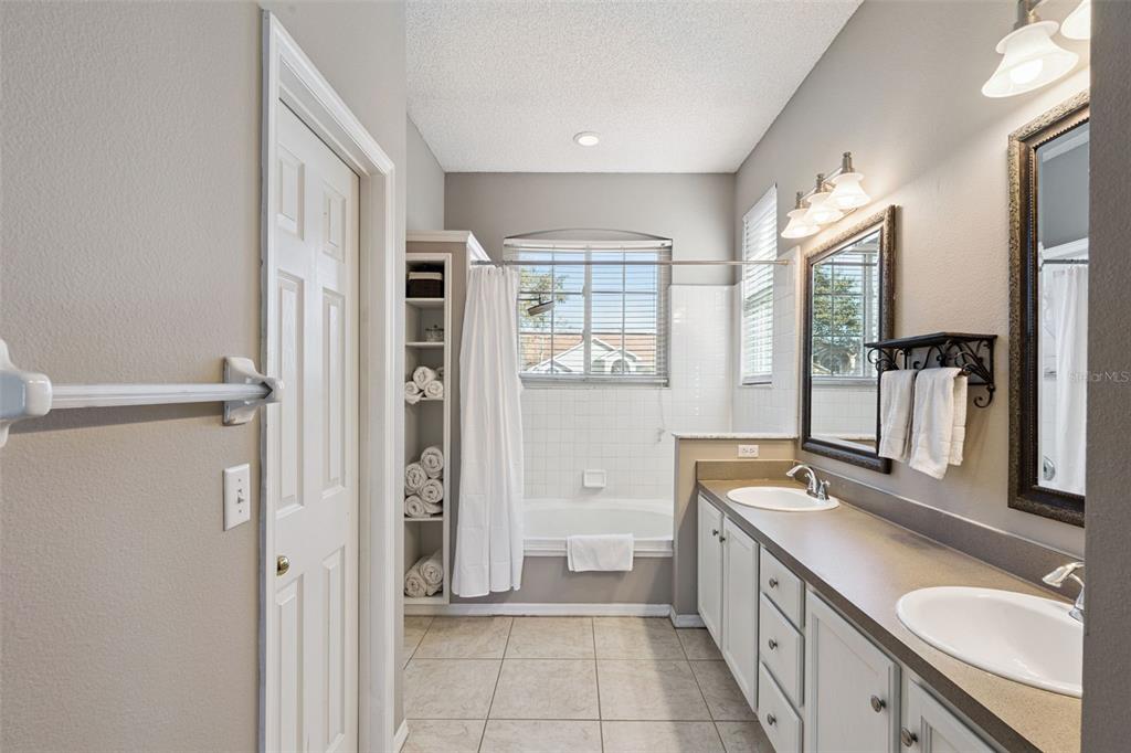 261 Mill Slough Road Oviedo, FL 32766 - Photo 25 of 62 a bathroom with a sink a mirror and a shower