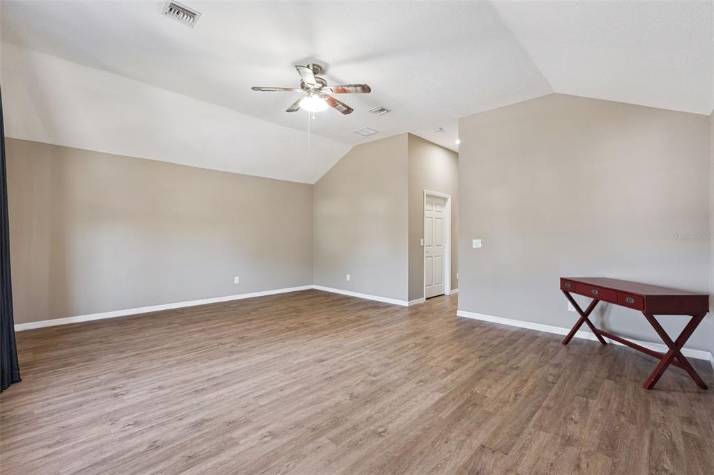 261 Mill Slough Road Oviedo, FL 32766 - Photo 35 of 62 a view of an empty room with wooden floor and a chandelier fan