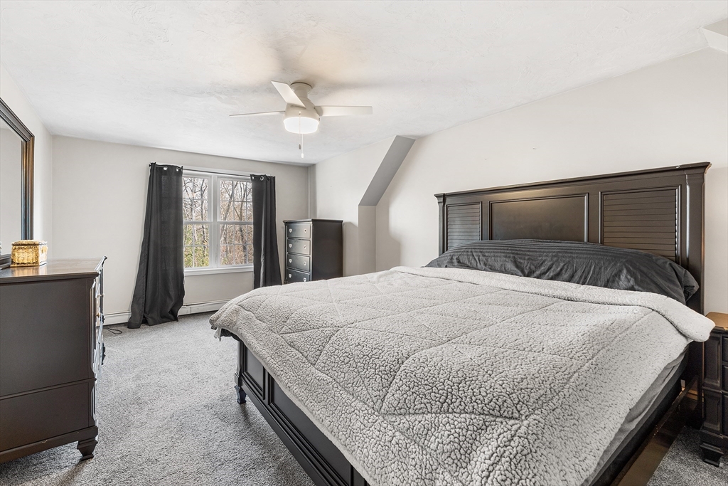 52 Deanville Road Attleboro, MA 02703 - Photo 12 of 30 a bedroom with a large bed and a chandelier