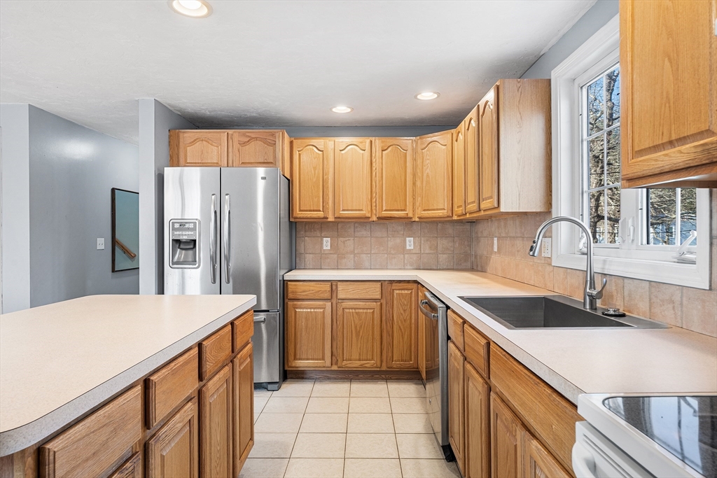 52 Deanville Road Attleboro, MA 02703 - Photo 7 of 30 a kitchen with stainless steel appliances granite countertop a sink stove and refrigerator