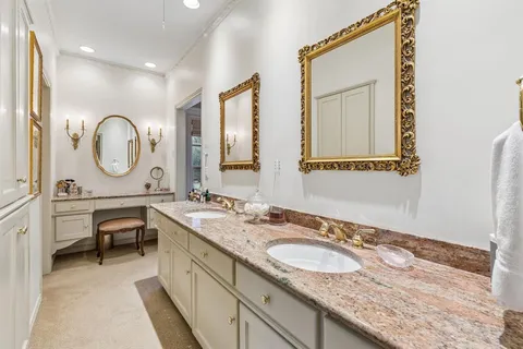 a en suite bathroom with a granite countertop sink and a mirror