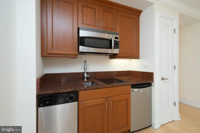 a kitchen with stainless steel appliances granite countertop a sink stove and microwave